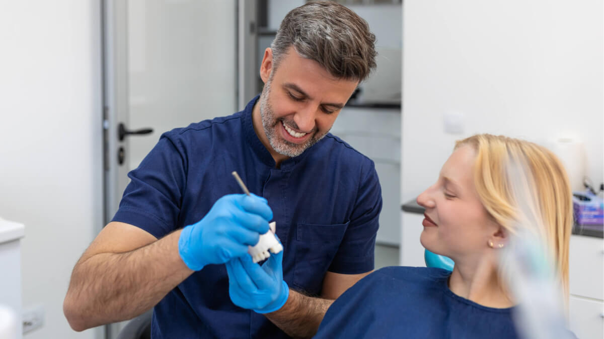 Dentist showing patient dental bridge